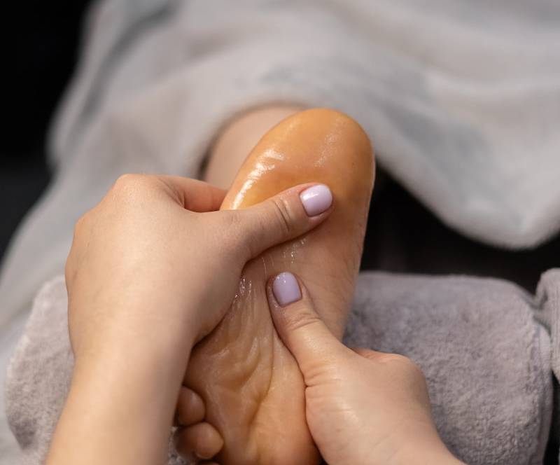 a woman getting a foot massage from a foot massager